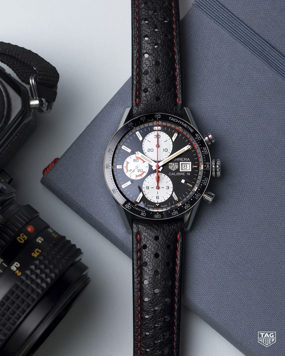 TAG Heuer Carrera chronograph resting on a camera